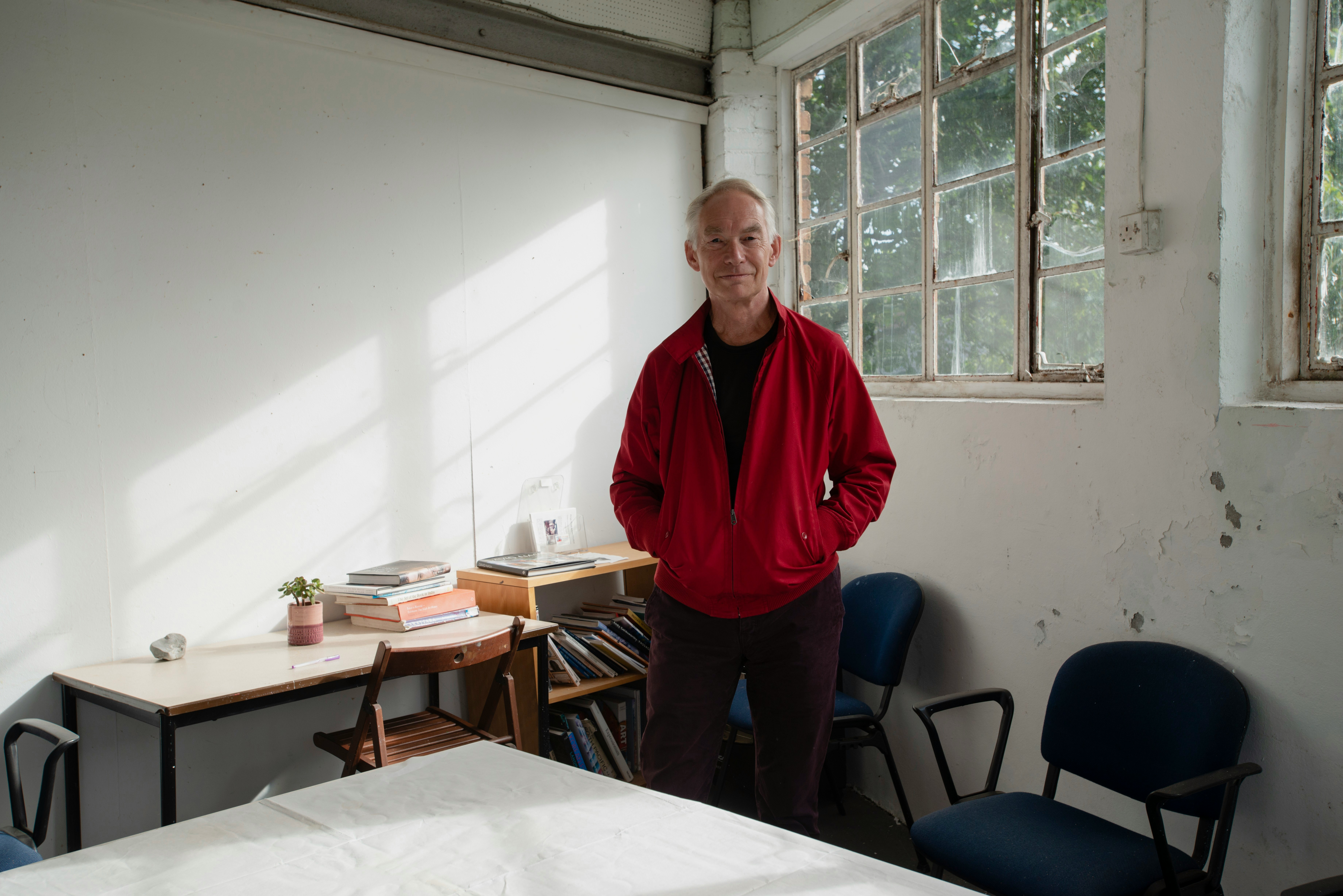 Man in red jacket stood in room